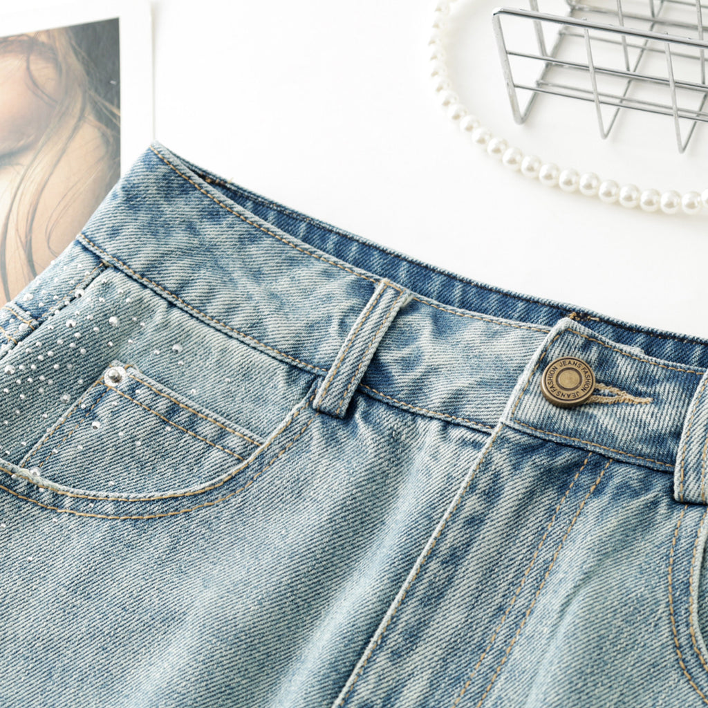 Women's high-waisted, washed blue denim mini skirt with rhinestone details and frayed edges; versatile and stylish.