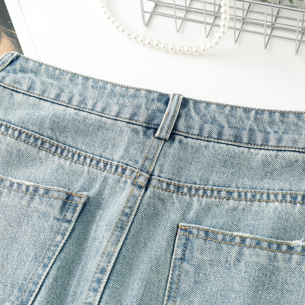 Women's high-waisted, washed blue denim mini skirt with rhinestone details and frayed edges; versatile and stylish.